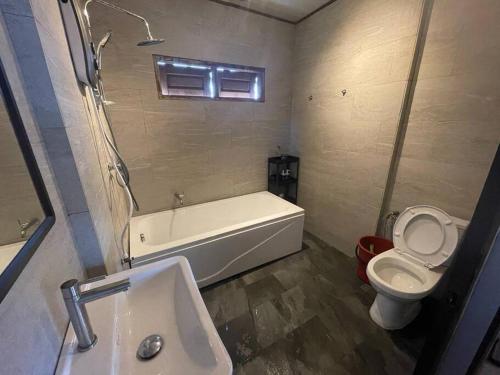 łazienka z wanną, toaletą i umywalką w obiekcie Rembulan Escape - The Container House w mieście Kampung Penarik