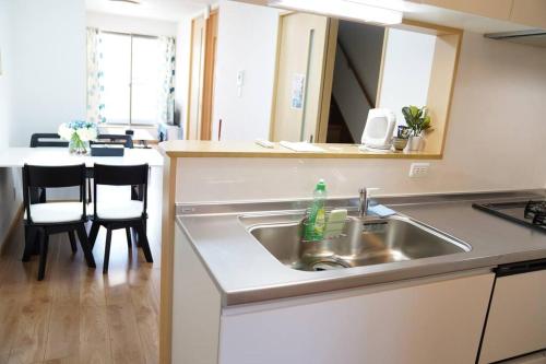 大阪市にある難波南3 room 115m2 Matsu1のシンクとテーブルと椅子のあるキッチン