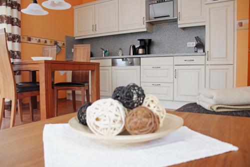 a kitchen with white cabinets and a bowl of balls on a table at Ferienwohnung Strandflair in Baabe