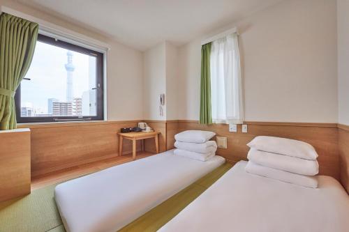 Habitación con 2 camas y ventana en 花築浅草和心ホテル, en Tokio