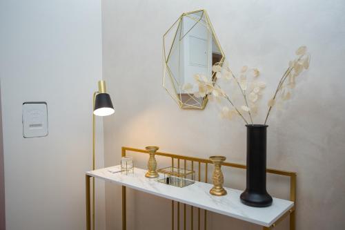 a table with a black vase and a mirror at Ferienhaus Kaimt Zell in Zell an der Mosel