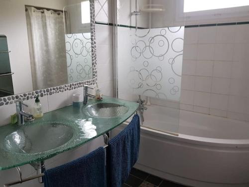 une salle de bain avec deux lavabos et une baignoire dans l'établissement Villa familiale dans un quartier résidentiel, à Saint-Raphaël
