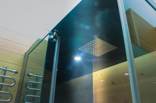a glass shower with a light in a room at EMMA´s Chalet in Mayrhofen