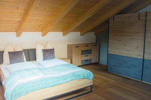 - une chambre avec un grand lit et un plafond en bois dans l'établissement EMMA´s Chalet, à Mayrhofen