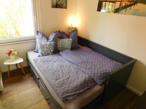 a small bed in a room with a window at Projekt Ferienhaus am See inkl. W-LAN, Betwäsche und Netflix in Jürgenshagen