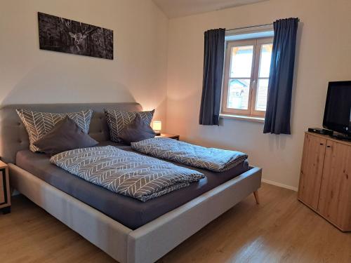 a couch sitting in a living room with a television at Ferienwohnung zum Peterbauer in Sachsenkam