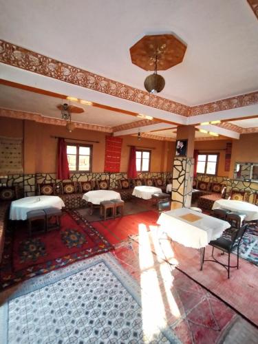 a room with tables and chairs in a building at auberge restaurant tizgui in Tinerhir