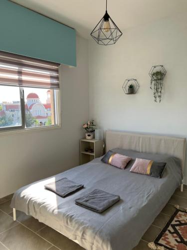 a bedroom with a bed with two towels on it at Joanna Court rooms in Larnaka