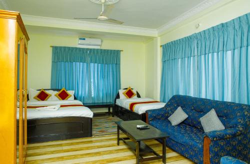 une chambre d'hôtel avec deux lits et un canapé dans l'établissement Hotel Homeland and Restaurant, à Pokhara