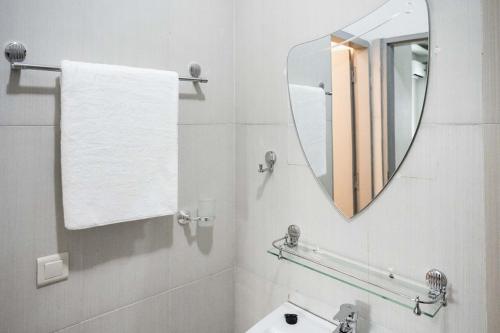a white bathroom with a mirror and a sink at Sublime appartement à Cocody Riviera Bonoumin . in Abidjan
