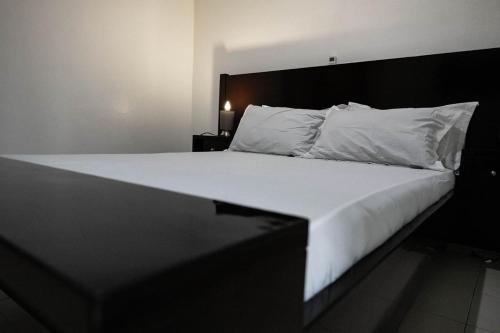 アビジャンにあるSublime appartement à Cocody Riviera Bonoumin .の大型ベッド(白いシーツ、枕付)