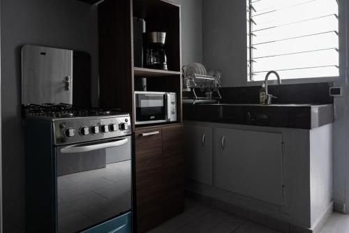 a kitchen with a stove and a microwave at Sublime appartement à Cocody Riviera Bonoumin . in Abidjan