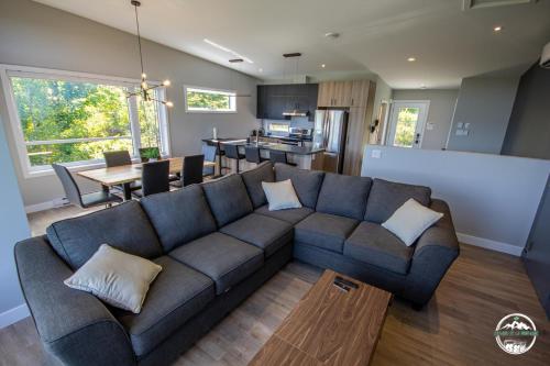 a living room with a blue couch and a kitchen at Les Rois de la Montagne in Saint-Jean-de-Matha
