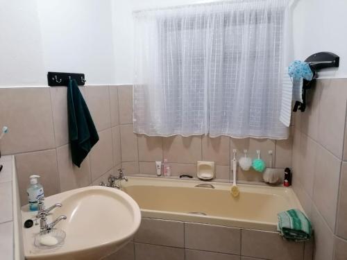 baño con lavabo y bañera con ventana en Seeskulp 18, en Margate