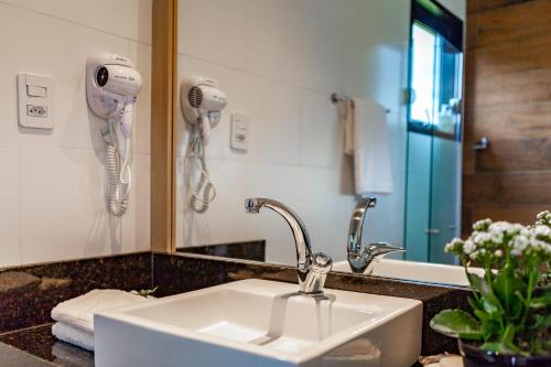 a bathroom with a sink and a mirror at Brumas Casa de Campo - Cambará do Sul in Cambara do Sul