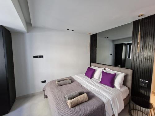 um quarto com uma cama grande e almofadas roxas em Raam Luxury Suites em Lárnaca