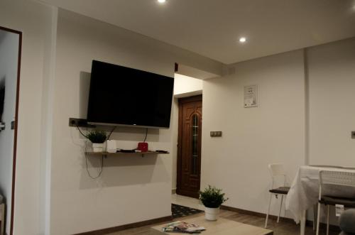 sala de estar con TV de pantalla plana en la pared en Kovács apartman Harkány en Harkány