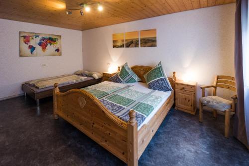 een slaapkamer met een houten bed en een stoel bij Ferienwohnung Jasmin in Wieden