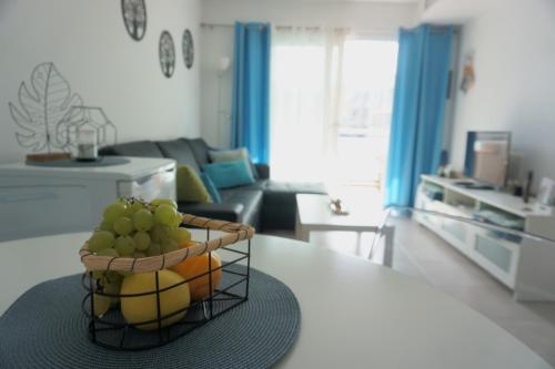 a basket of fruit on a table in a living room at Blue Ocean Corralejo: Sunny terrace, pool, wifi in Corralejo