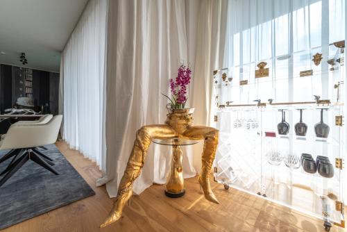 a gold chair with a vase on a table in a room at Exclusive 2BR Skyline Penthouse by HM in Vienna