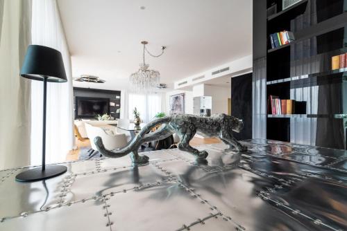 a living room with a dinosaur statue on a glass table at Exclusive 2BR Skyline Penthouse by HM in Vienna