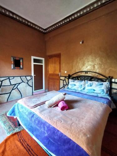a bedroom with a large bed with a large blue bedspread at auberge restaurant tizgui in Tinerhir