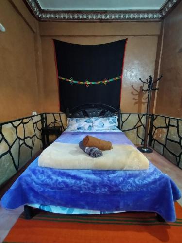 a bedroom with a bed with a blue blanket at auberge restaurant tizgui in Tinerhir