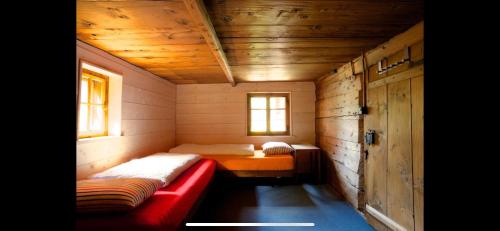Habitación pequeña con sofá rojo en una cabaña en Alpenlodge Tgèsa Surrein Giassa10, en Sedrun
