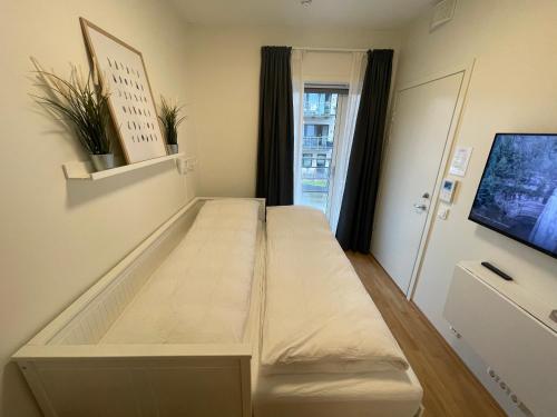 ein großes Bett in einem Zimmer mit einem TV in der Unterkunft Clean and Modern - 25 Min to Oslo City & OSL in Lillestrøm