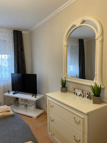 a living room with a dresser and a mirror at Bemma Apartman in Budapest