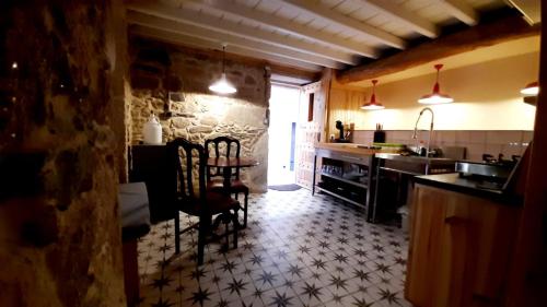 a kitchen with a table and chairs in a room at Penamacor Cozy Nook House in Penamacor