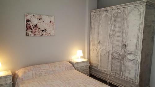 1 dormitorio con 1 cama y un gran armario de madera en Apartamento acogedor en el centro de Valdepeñas, en Valdepeñas