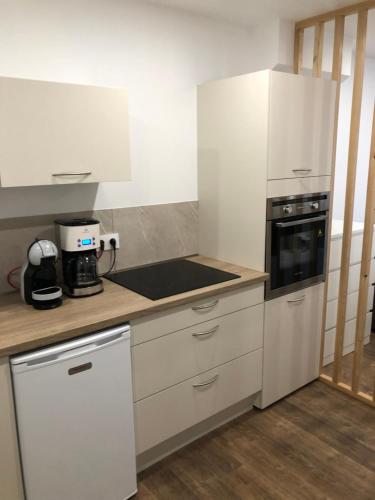 une cuisine avec des armoires blanches et un four à plaques de cuisson dans l'établissement Berck appartement cosy, à Berck-sur-Mer