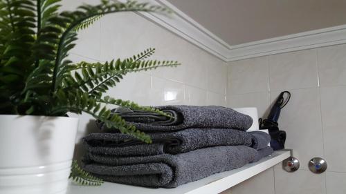 una pila de toallas sentadas en un estante en un baño en Apartamento acogedor en el centro de Valdepeñas, en Valdepeñas