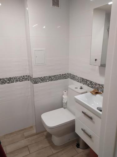 uma casa de banho branca com um WC e um lavatório em Apartament przy kładce em Przemyśl