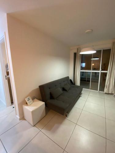 a living room with a couch and a table at Mediterrâneo 507 - Todo Equipado, Ar Condicionado, Churrasqueira na Varanda, Internet Fibra 600MB, Estacionamento Grátis in Cabo Frio