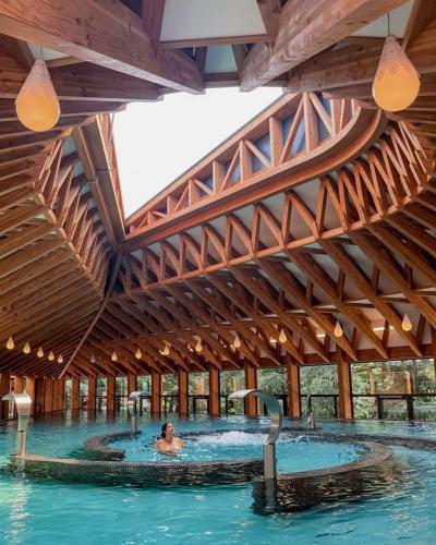 une personne dans une piscine d'un bâtiment dans l'établissement Villa moderne avec piscine Aubenas, à Saint-Étienne-de-Fontbellon