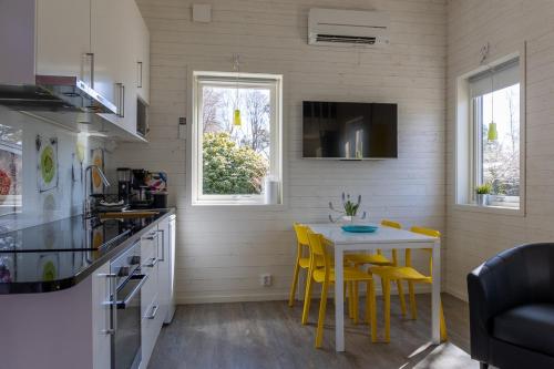 a kitchen with a table and yellow chairs in a room at Havsstugan in Sölvesborg