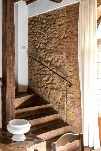 a bathroom with a stone wall and a toilet at Borgo Il Poggiaccio Residenza d'Epoca in Sovicille