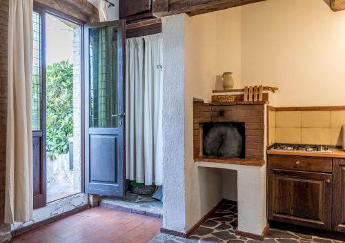 a kitchen with a stove and a window and a door at Borgo Il Poggiaccio Residenza d'Epoca in Sovicille