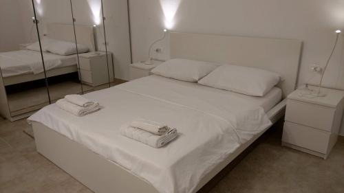 Un dormitorio con una cama blanca con toallas. en Mira, en Splitska