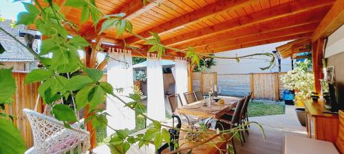 a patio with a wooden pergola with a table and chairs at RIVER KOLPA APARTMENT, Griblje ob reki Kolpi in Gradac