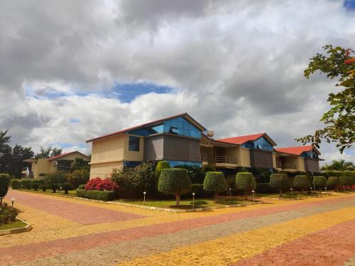 a row of houses on a street with bushes at Bandipur Wildlife Resort & Spa, Bandipur in Bandipūr