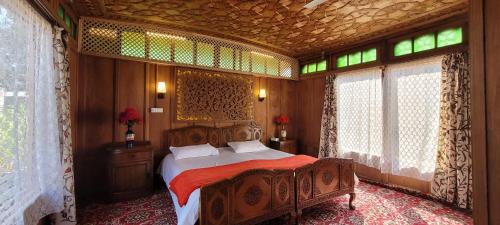 a bedroom with a bed in a room with windows at Lily Of The World Houseboat in Srinagar