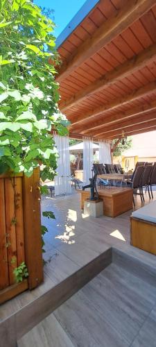 acovered patio with a table and chairs and a tree at RIVER KOLPA APARTMENT, Griblje ob reki Kolpi in Gradac