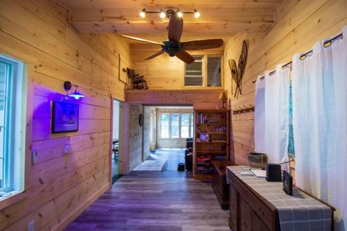 a hallway in a log cabin with a ceiling fan at Cozy Accessible Waterfront Cottage on Healey Lake in Bracebridge