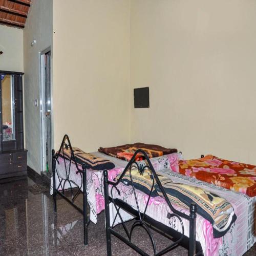 a room with two beds and two chairs at Evergreen homestay by StayApart, Coorg in Madikeri