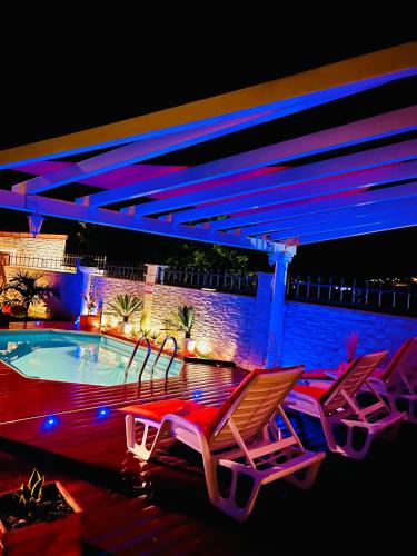 - deux chaises longues et une piscine la nuit dans l'établissement Villa Paradis, au François