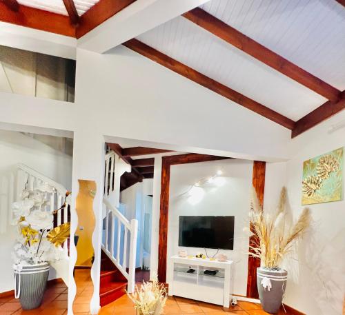 salon z białymi ścianami i drewnianymi belkami stropowymi w obiekcie Villa Paradis w mieście Le François