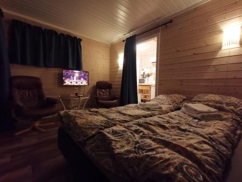 a bedroom with a bed and a television in it at Utsikten in Gjesvær